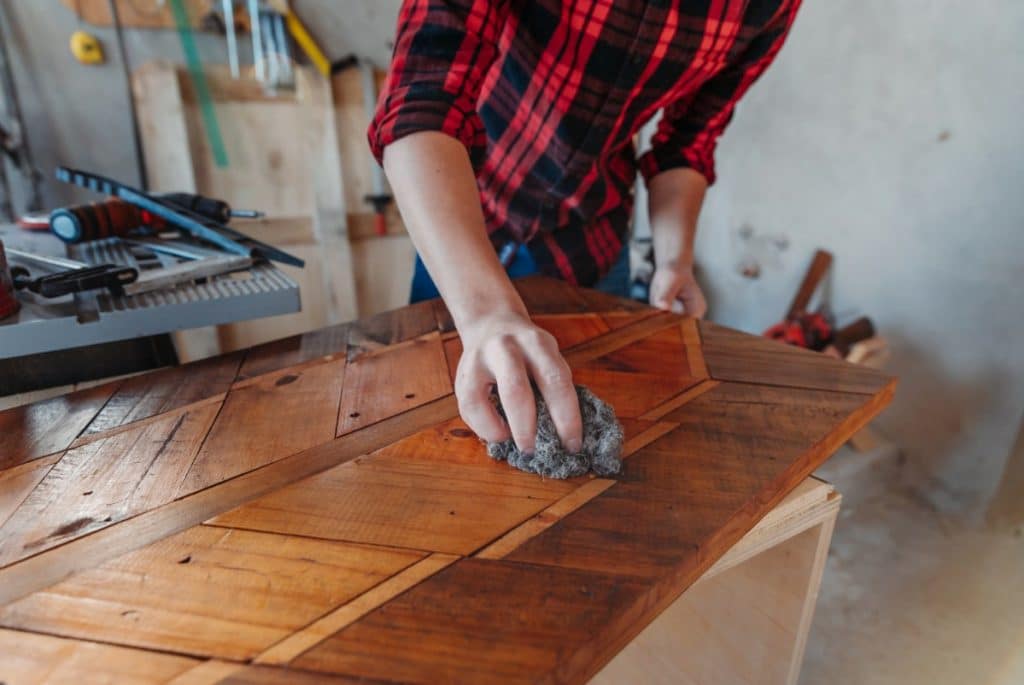 Applying wax to cabinet door.