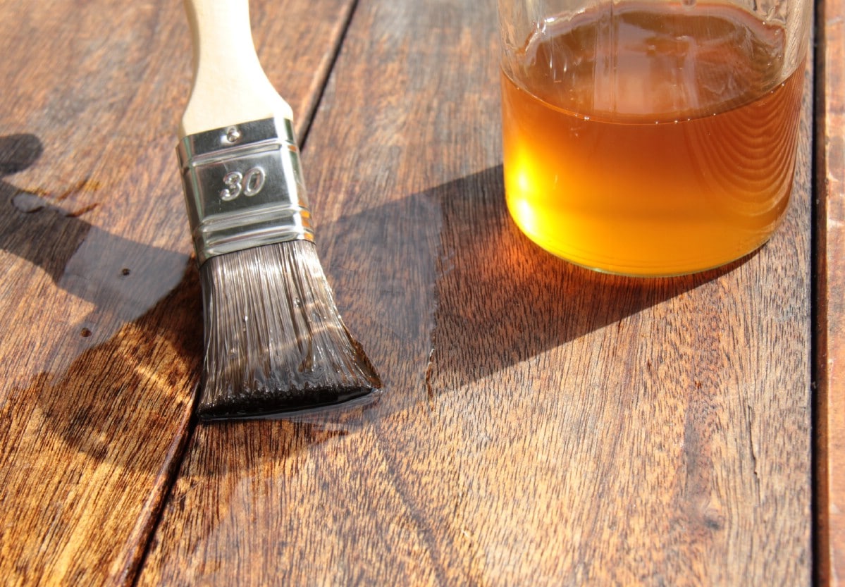 Applying linseed oil to a wooden desk.